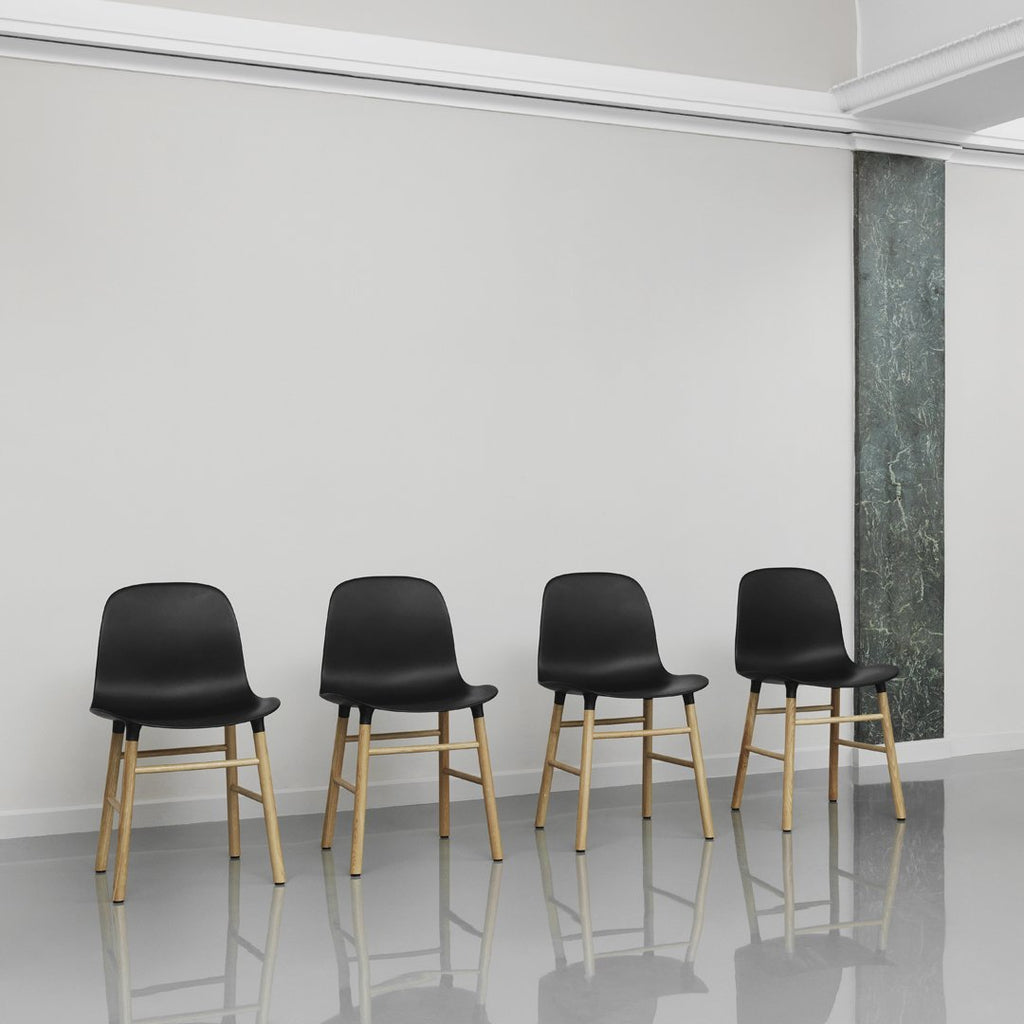 Chaise de salle à manger contemporaine en plastique moulé et chêne avec système d'assemblage intégré.