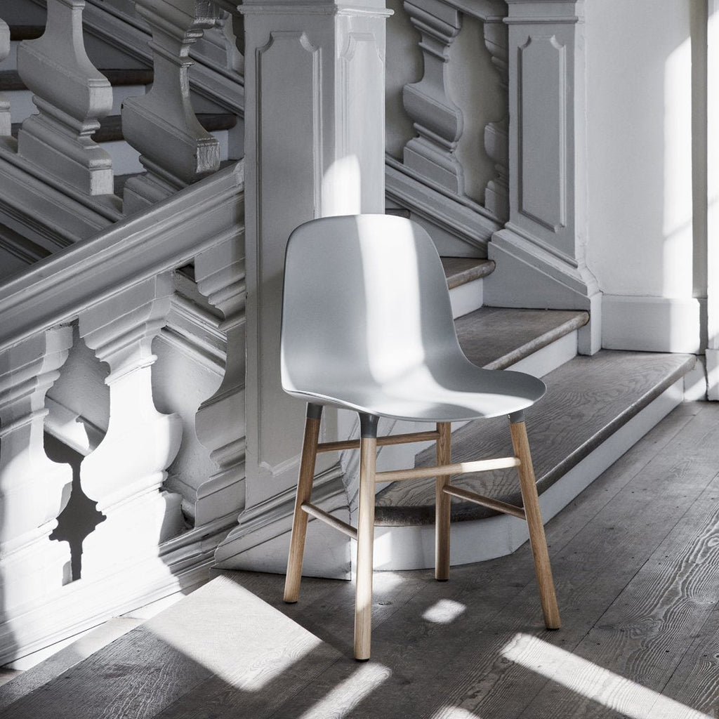 Chaise de salle à manger contemporaine en plastique moulé et chêne avec système d'assemblage intégré.