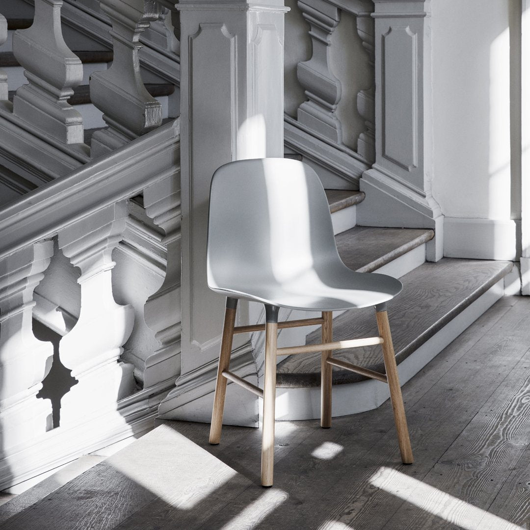 Chaise de salle à manger contemporaine en plastique moulé et chêne avec système d'assemblage intégré.