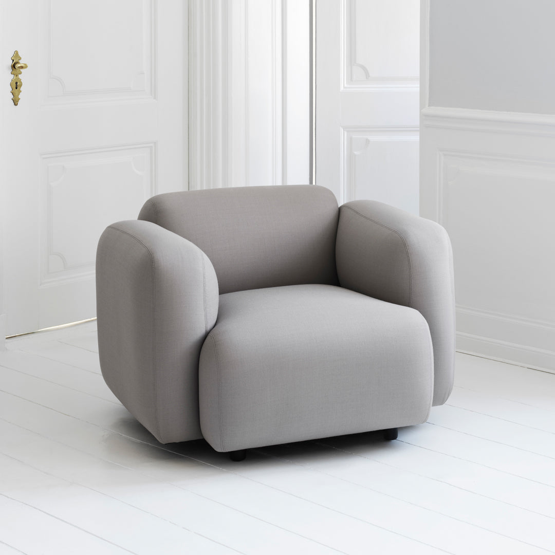 Fauteuil de salon rembourré minimaliste avec silhouette aux courbes douces pour le salon