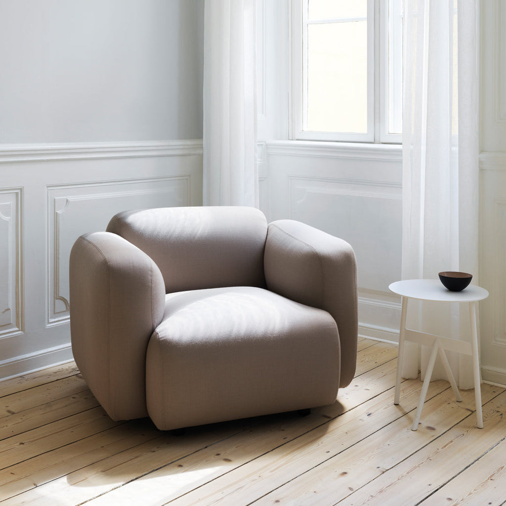 Fauteuil de salon rembourré minimaliste avec silhouette aux courbes douces pour le salon
