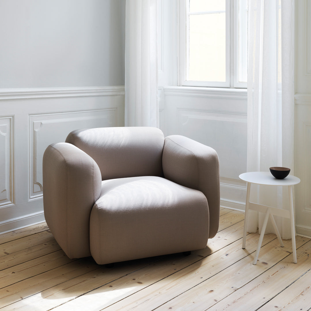 Fauteuil de salon rembourré minimaliste avec silhouette aux courbes douces pour le salon