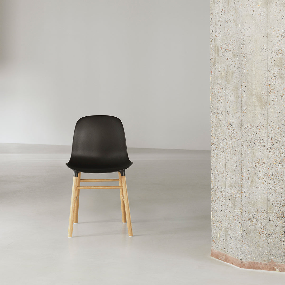 Chaise de salle à manger contemporaine en plastique moulé et chêne avec système d'assemblage intégré.