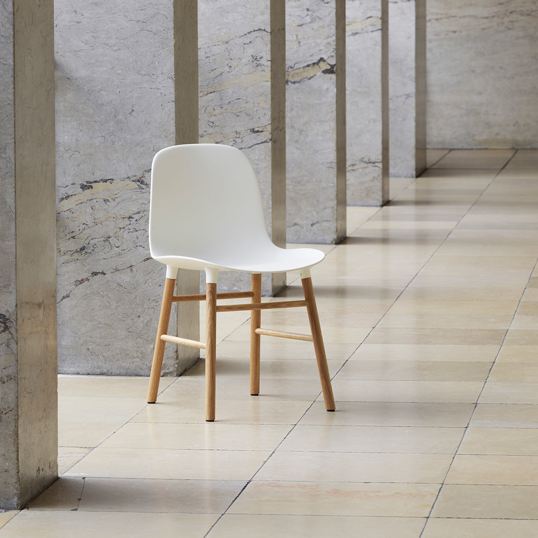 Chaise de salle à manger contemporaine en plastique moulé et chêne avec système d'assemblage intégré.