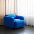 Fauteuil de salon rembourré minimaliste avec silhouette aux courbes douces pour le salon