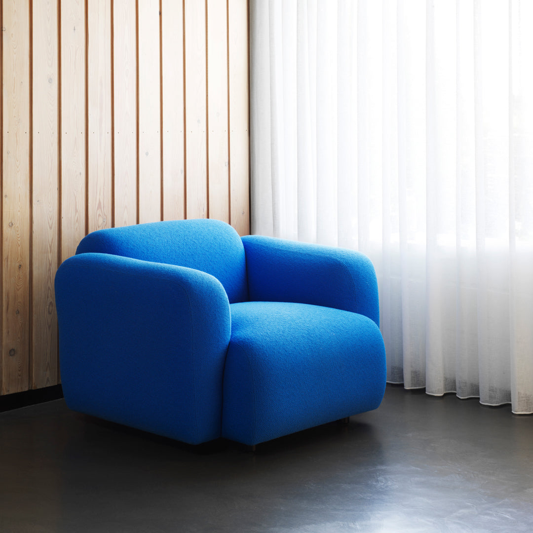 Fauteuil de salon rembourré minimaliste avec silhouette aux courbes douces pour le salon