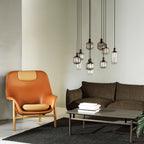 Fauteuil de salon contemporain à dossier haut et tapissé, avec silhouette organique drapée et pieds en chêne pour le salon
