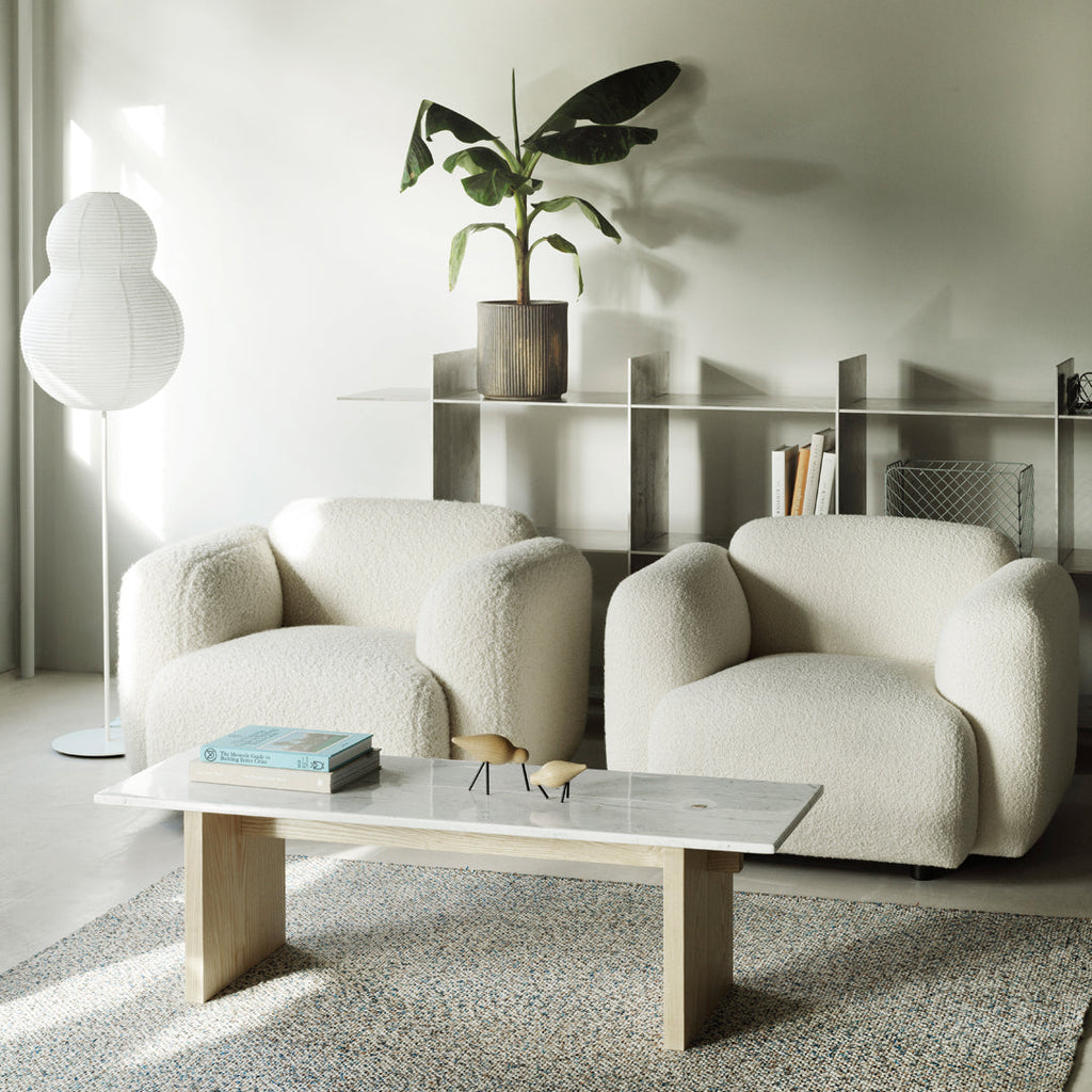 Fauteuil de salon rembourré minimaliste avec silhouette aux courbes douces pour le salon