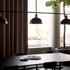 Chaise d'appoint minimaliste Bauhaus en acier et bois avec assise arrondie et dossier flexible pour salle à manger