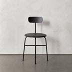 Chaise d'appoint minimaliste Bauhaus en acier et bois avec assise arrondie et dossier flexible pour salle à manger