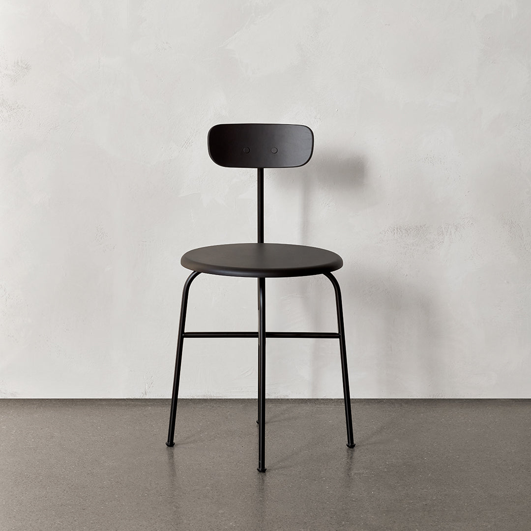 Chaise d'appoint minimaliste Bauhaus en acier et bois avec assise arrondie et dossier flexible pour salle à manger